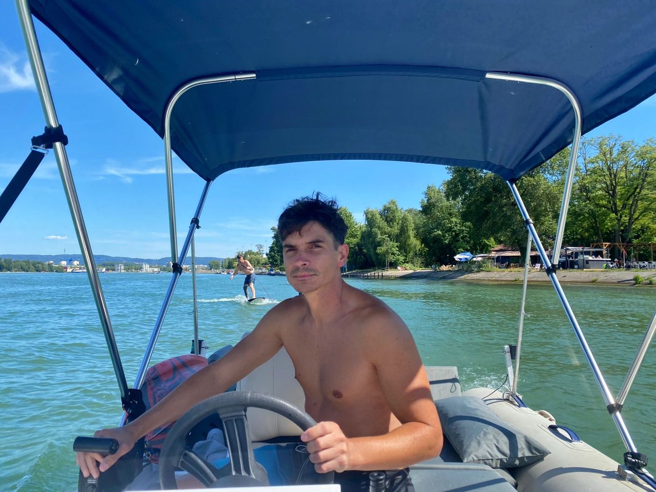 Foilen auf dem Rhein hinter dem Motorboot in Basel